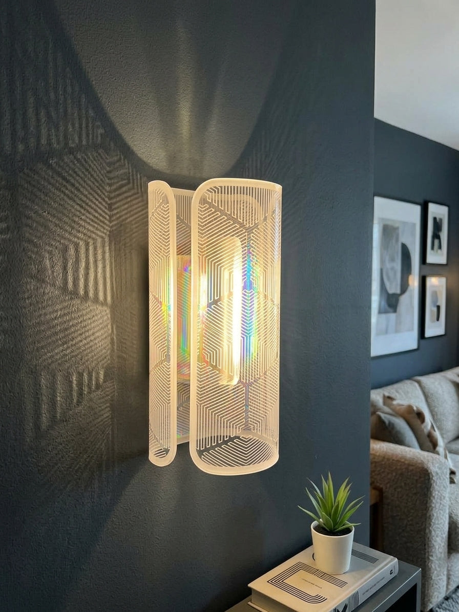 A modern wall sconce light fixture with a warm white textured mesh shade and a glowing cylindrical bulb inside, mounted on a dark gray wall in a contemporary living room setting.