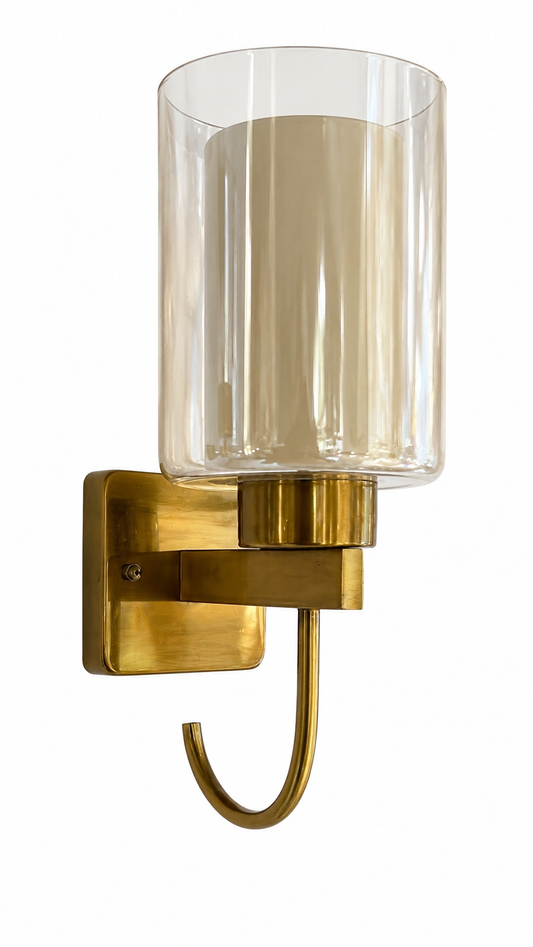 Modern brass wall sconce with clear cylindrical glass shade and curved J-arm