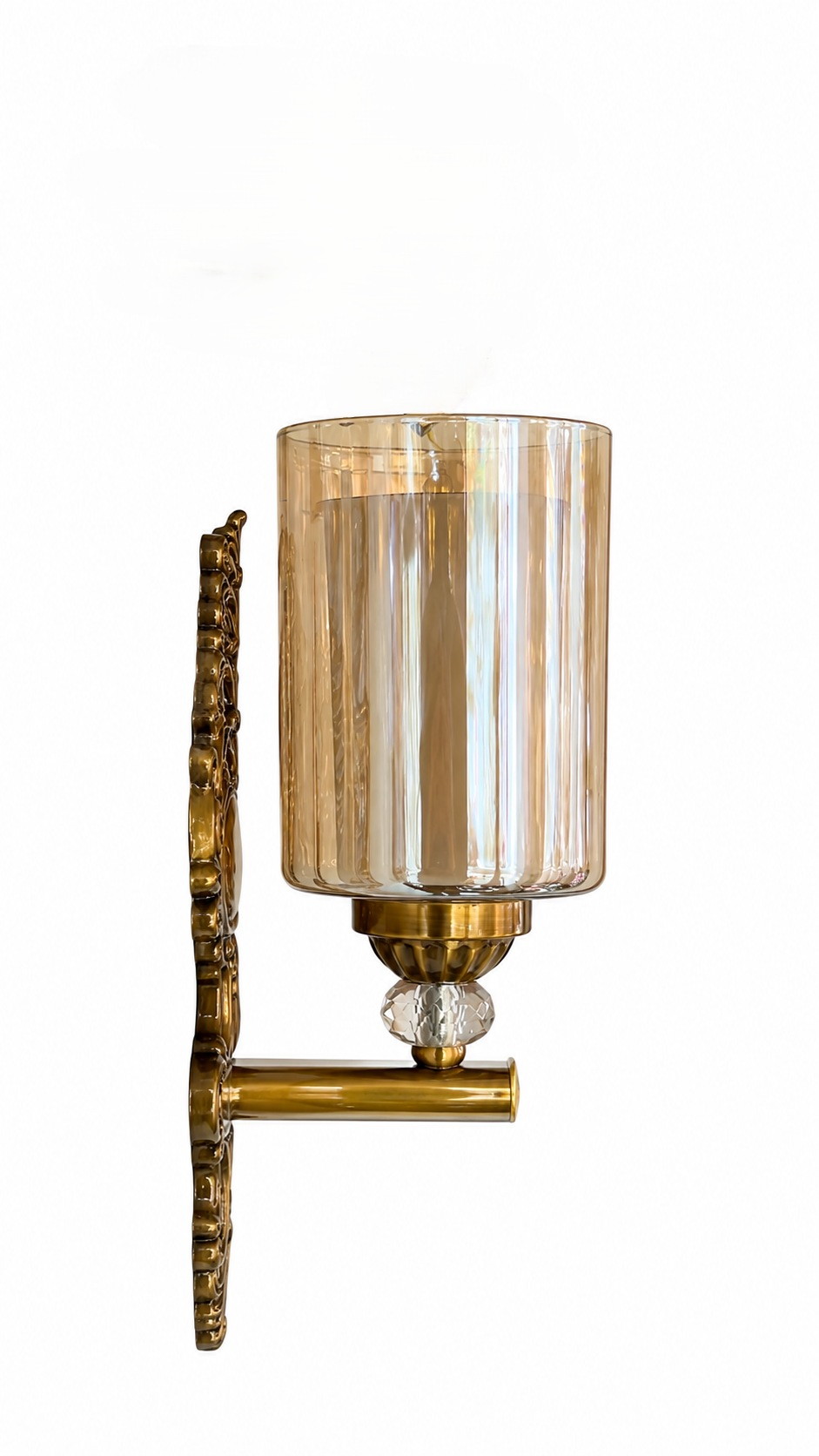 A wall-mounted sconce with a vertical ribbed amber-tinted glass shade, a polished brass backplate and arm, and a faceted clear crystal accent on a plain white background.